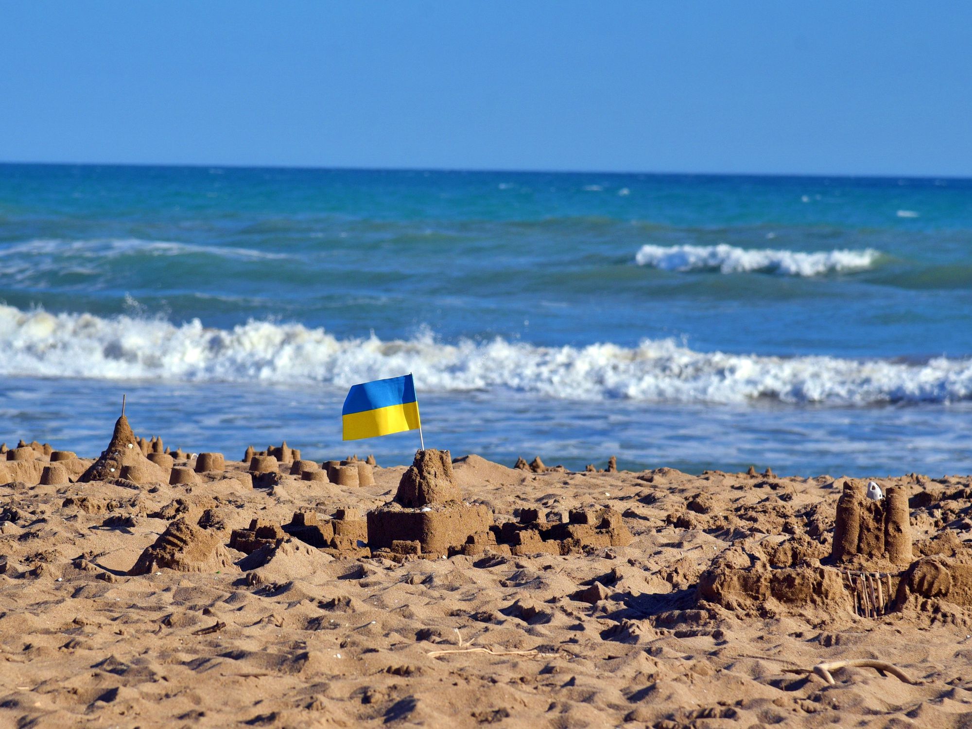 Photo of a sand castle with the Ukrainian flag on top