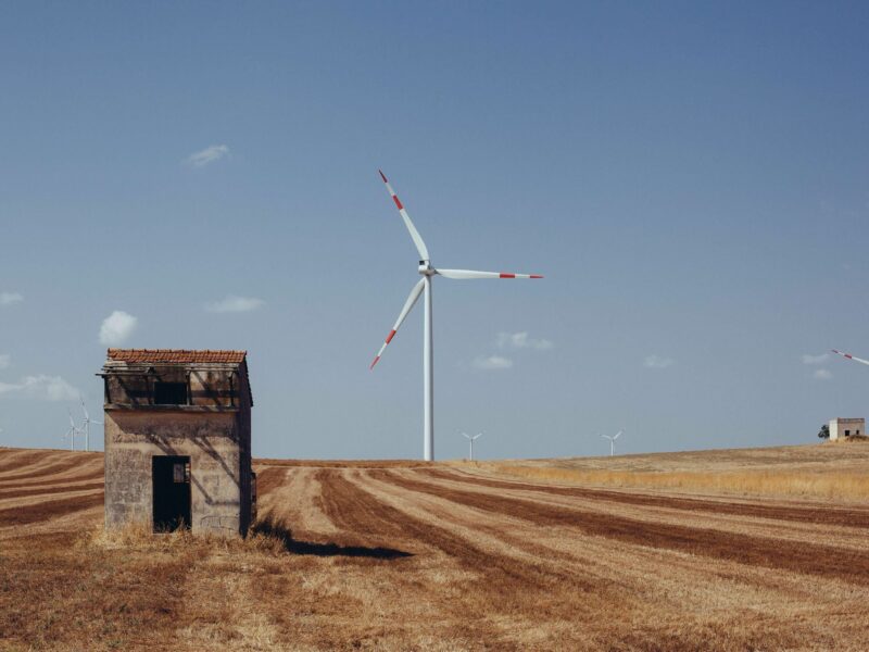 photo of a shack and a windmill on a farm