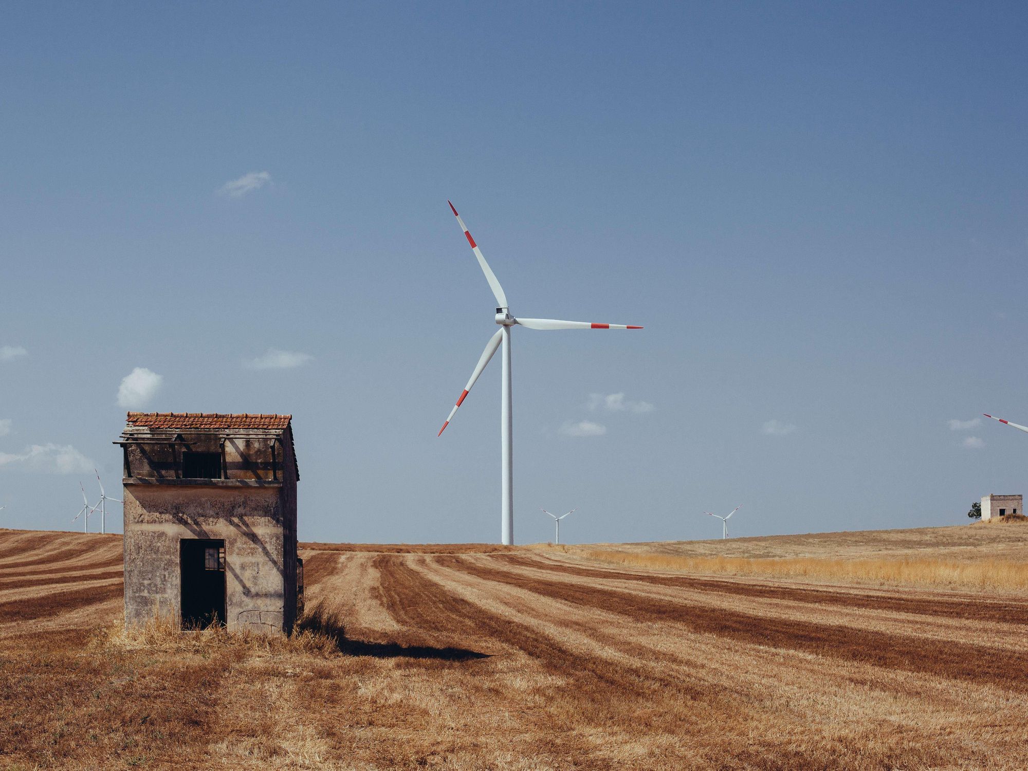 photo of a shack and a windmill on a farm