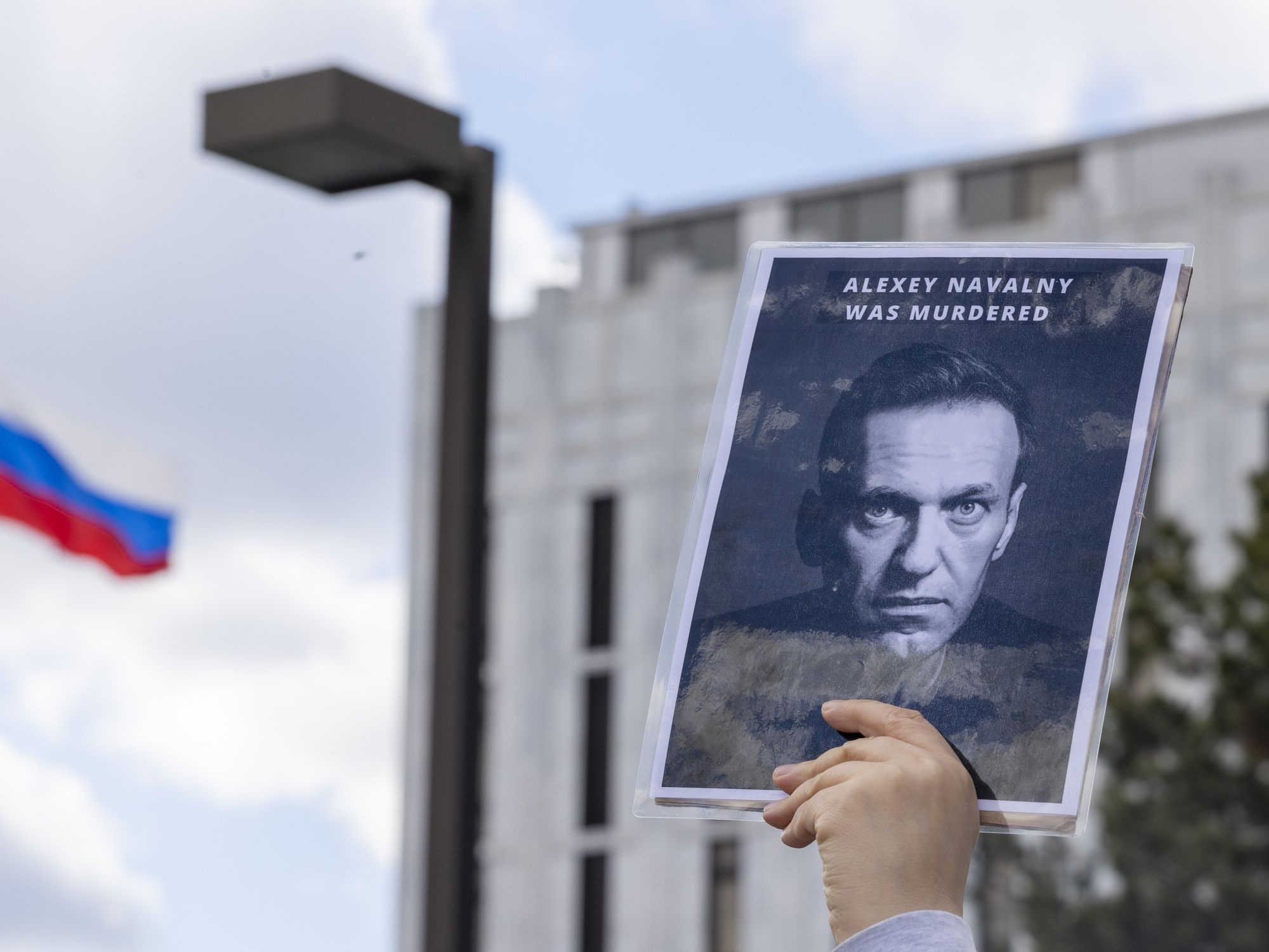 photo of a sign with a photo of Navalny