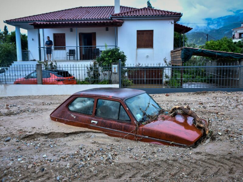 photo of a small red car buried in sand