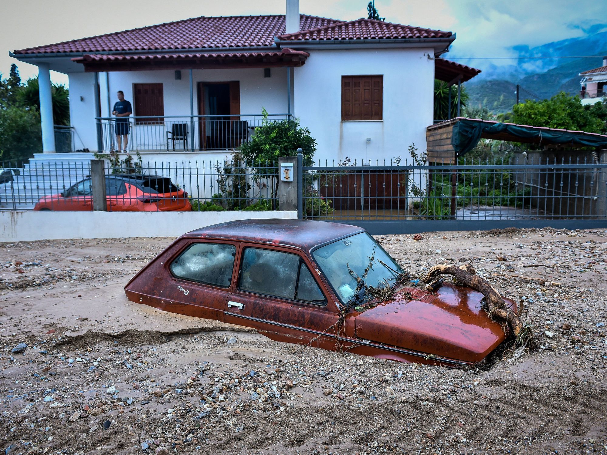 photo of a small red car buried in sand