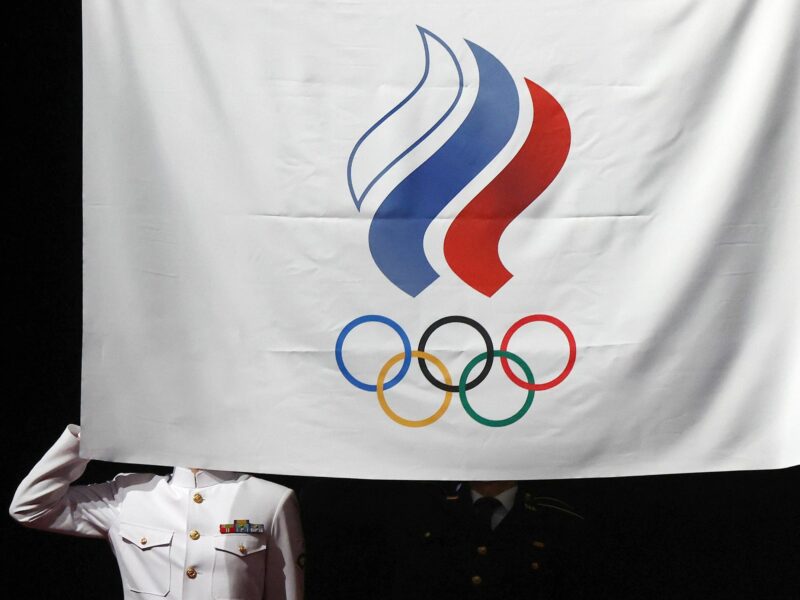photo of a soldier being blocked by the Russian olympic committee flag