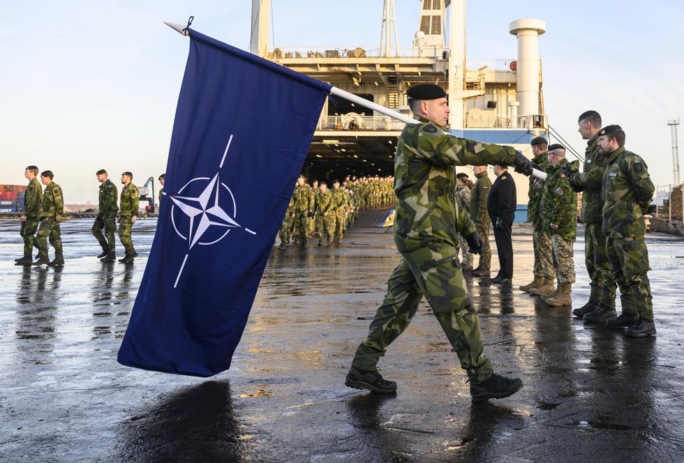 photo of a soldier carrying a nato flag
