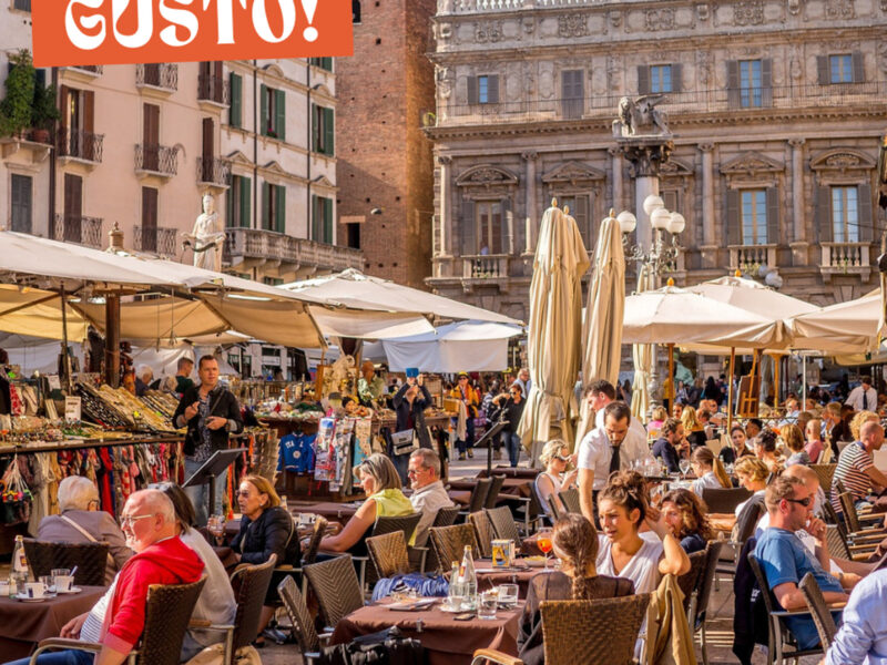 Photo of a square in Verona with people eating and drinking at restaurant terraces