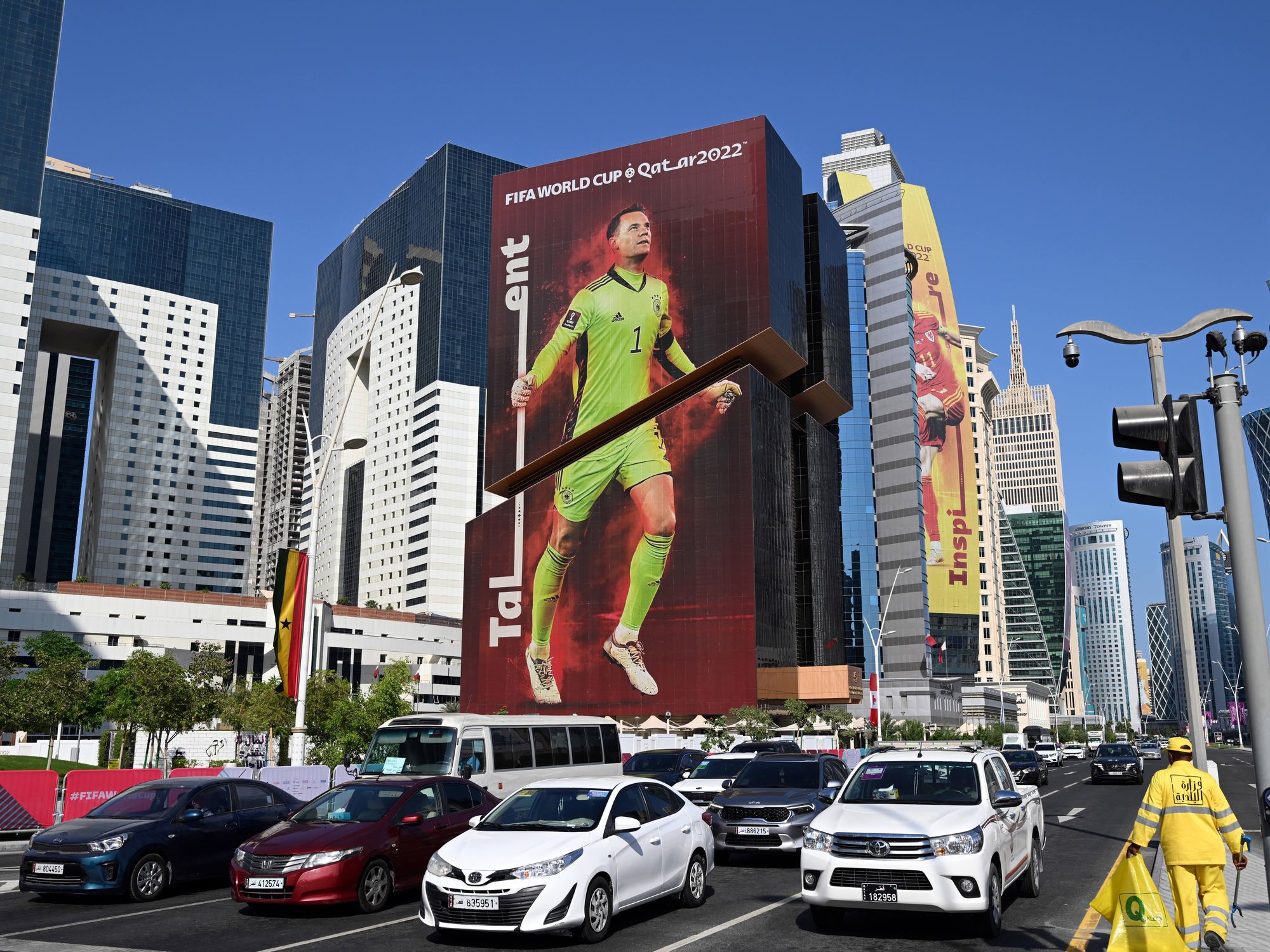Photo of a street in Doha, Qatar, with a building displaying a giant ad for the 2022 World Cup