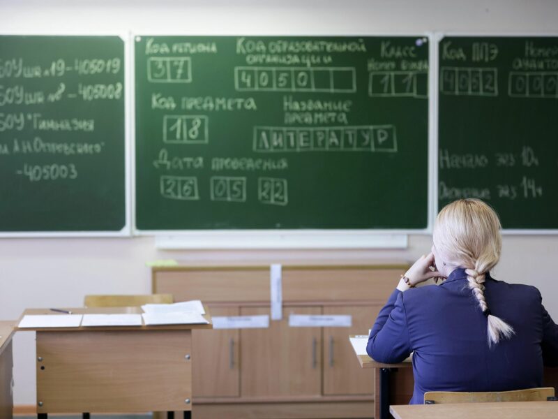 Photo of a student facing a whiteboard in a classroom