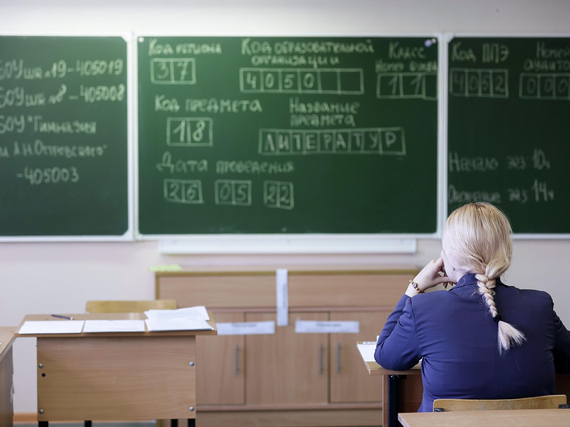 Photo of a student facing a whiteboard in a classroom
