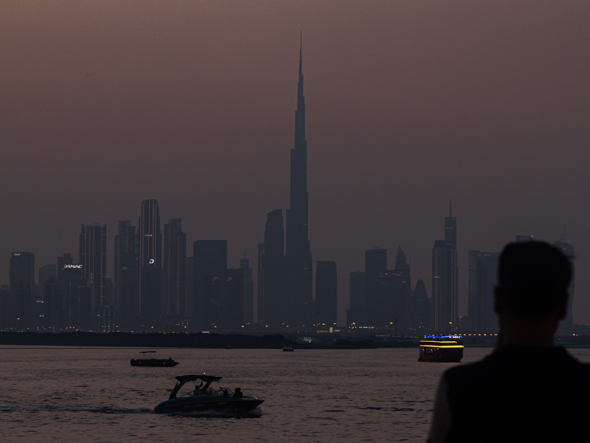 Photo of a sunset over Dubai Creek Harbor with the Dubai skyline in the background