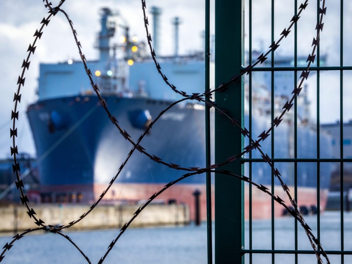 photo of a tanker ship behind barbed wire