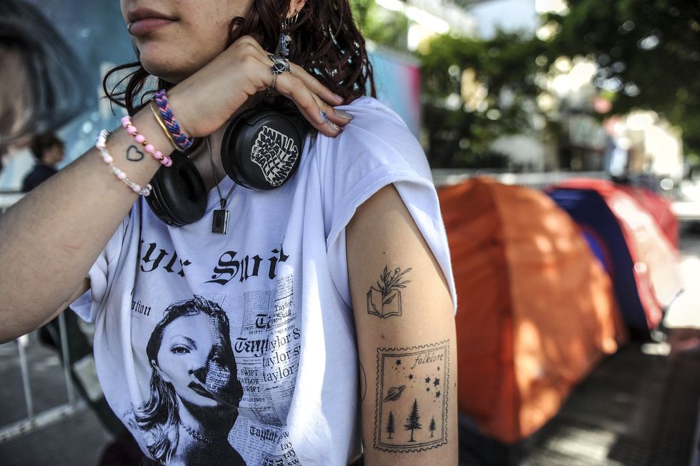 photo of a teenage girl wearing a taylor swift t-shirt with tattoos