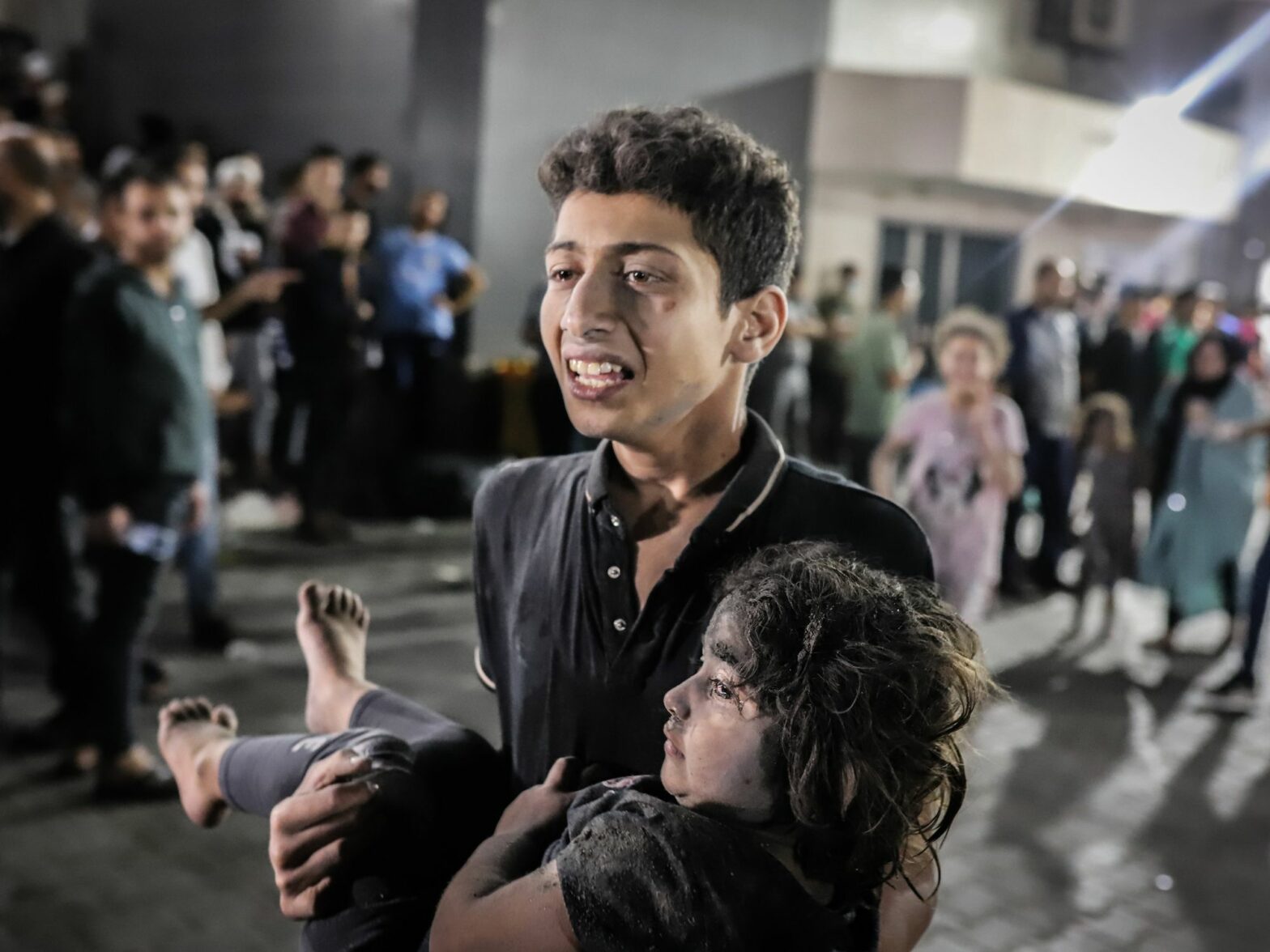photo of a teenager carrying an injured child