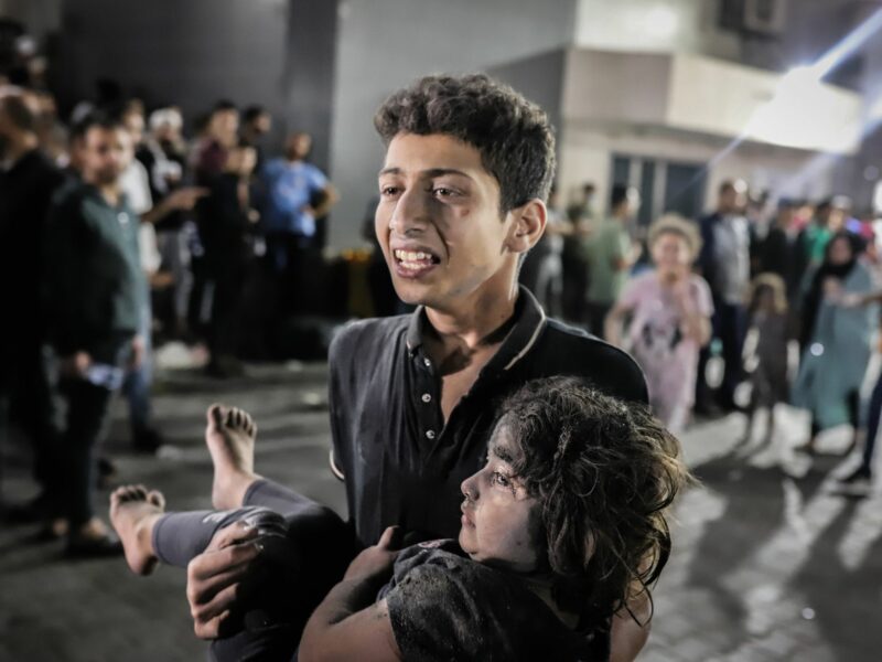 photo of a teenager carrying an injured child