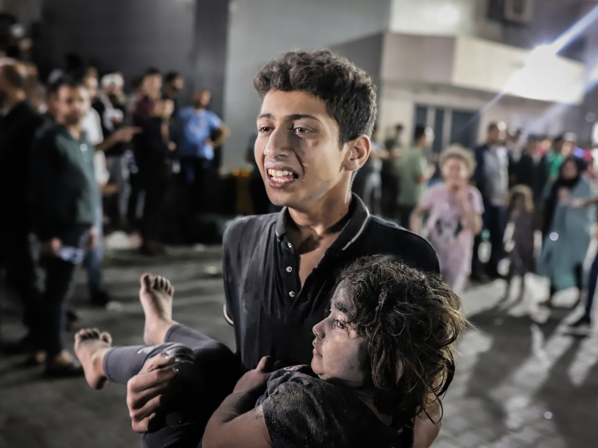 photo of a teenager carrying an injured child