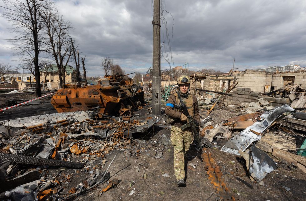 Photo of a Ukrainian soldier walking through the destruction of war