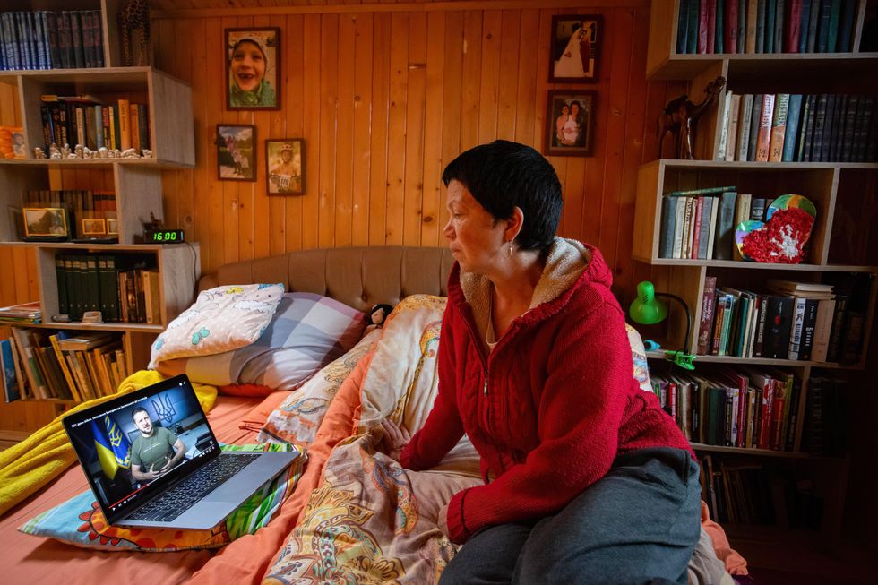 Photo of a Ukrainian woman watching Volodymyr Zelensky's speech