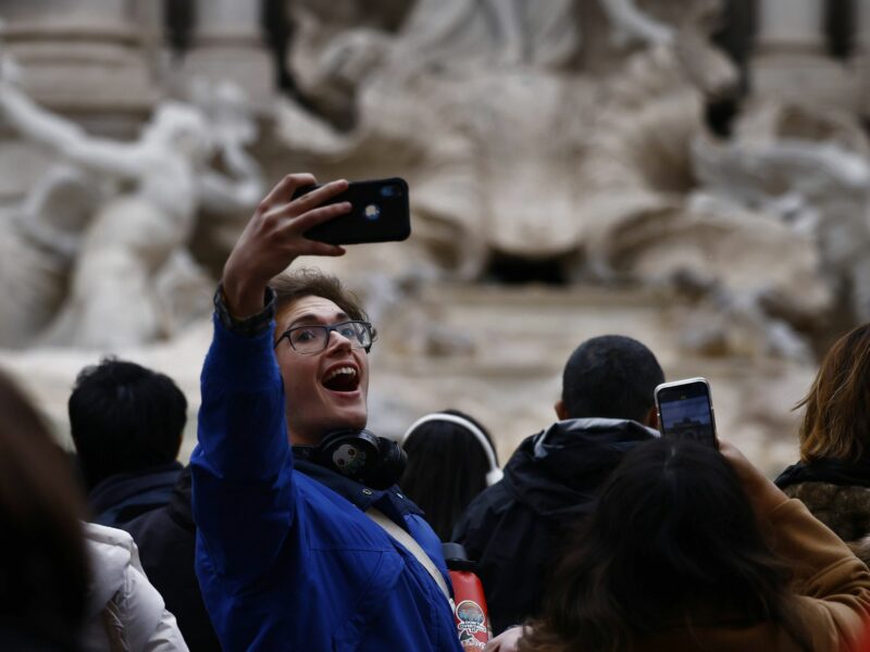 photo of A visitor takes a selfie after the reopening of the Trevi Fountain in Rome