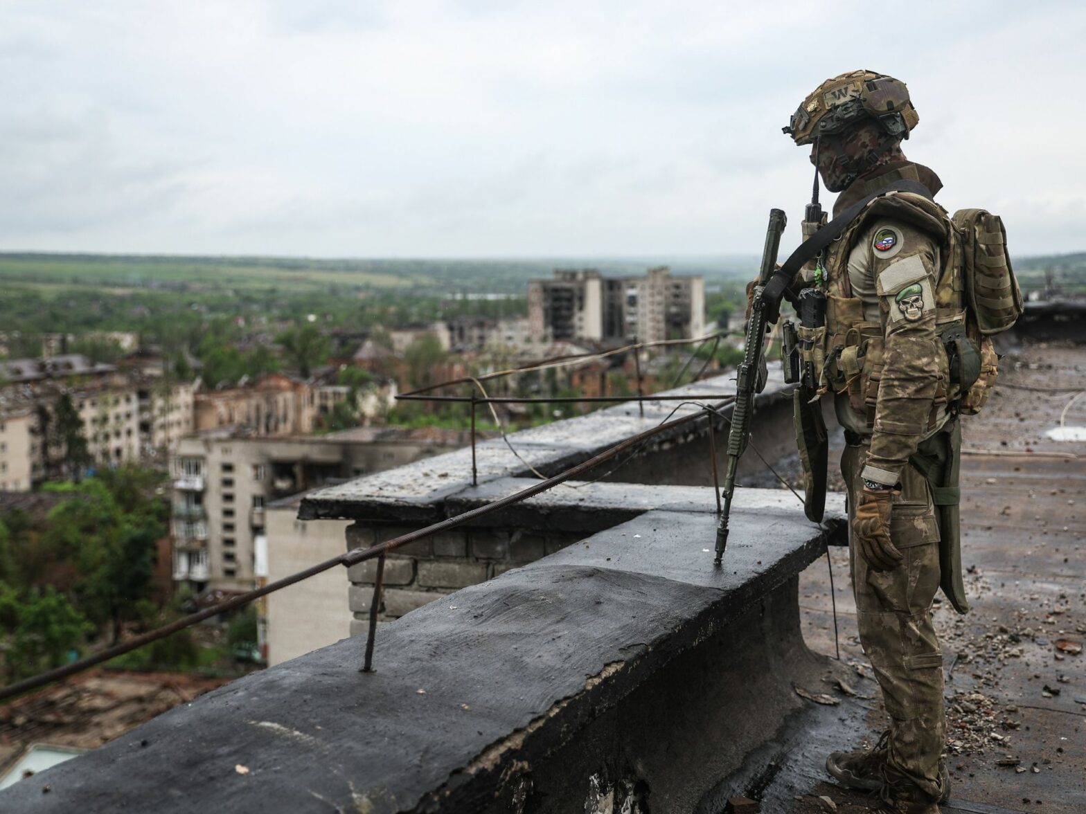 Photo of a Wagner mercenary in full military gear standing on a rooftop in the Ukrainian city of Artemovsk, near Bakhmut, back in May