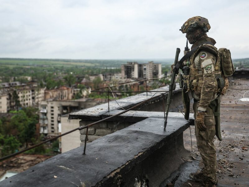 Photo of a Wagner mercenary in full military gear standing on a rooftop in the Ukrainian city of Artemovsk, near Bakhmut, back in May