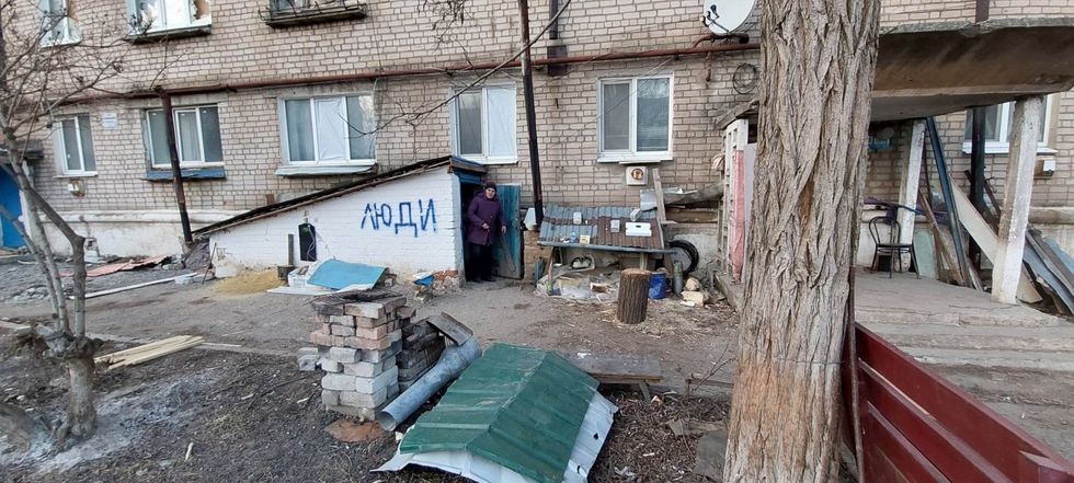 Photo of a woman coming out of one of the basements with the word "People" written on the side of the entrance.
