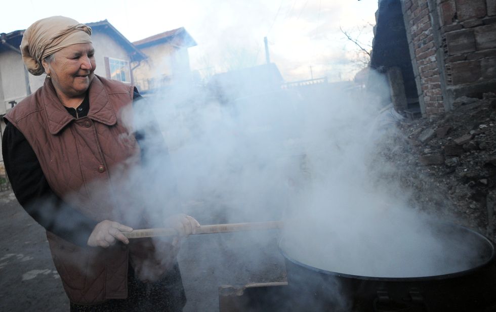 Photo of a woman cooking in the streets of the Roma neighbourhood of 'Fakulteta' in Sofia, Bulgaria