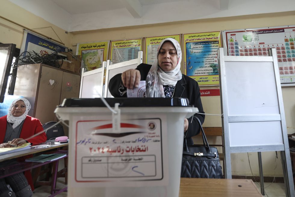 photo of a woman dropping ballot into box