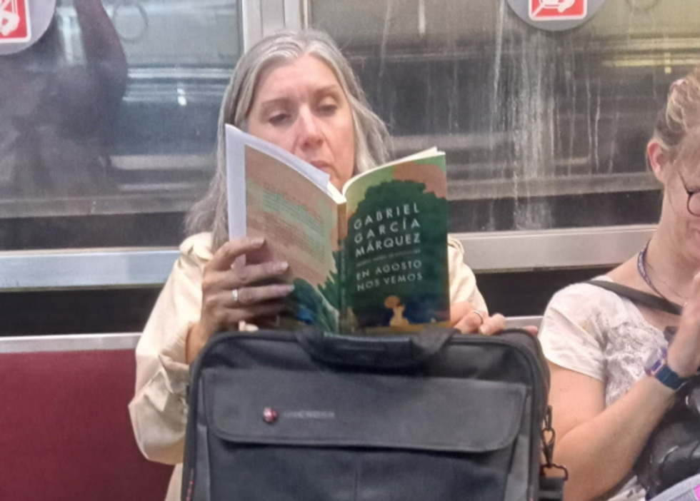 Photo of a woman ​reading ​Gabo's newly-published En agosto nos vemos on the metro