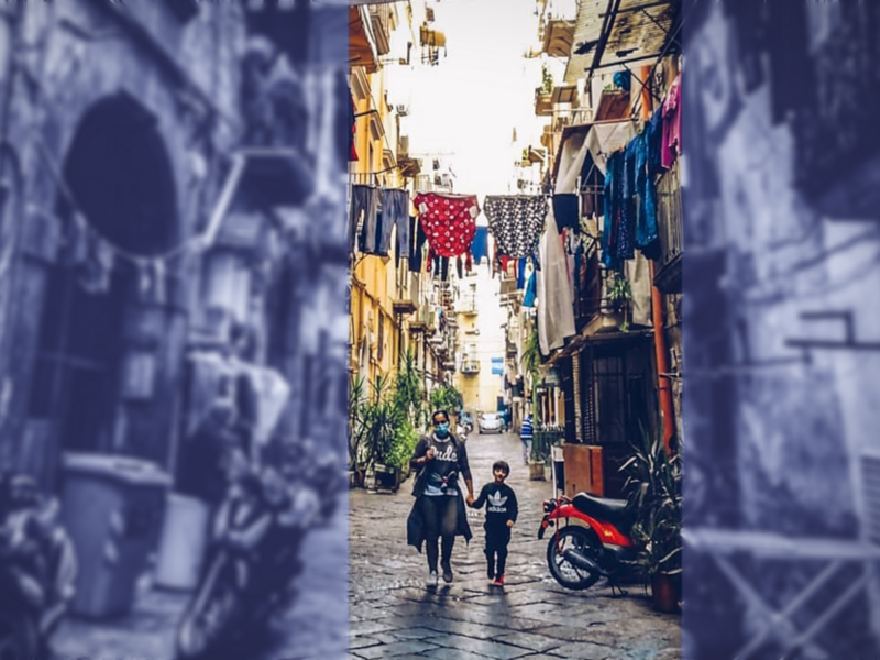 Photo of a woman holding a child's hand in the Sanità neighborhood of Naples