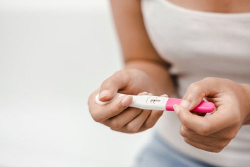 Photo of a woman holding a negative pregnancy test