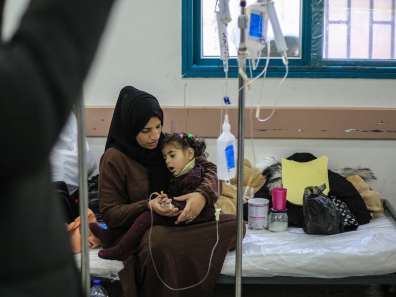 photo of a woman holding a young girl who has an IV