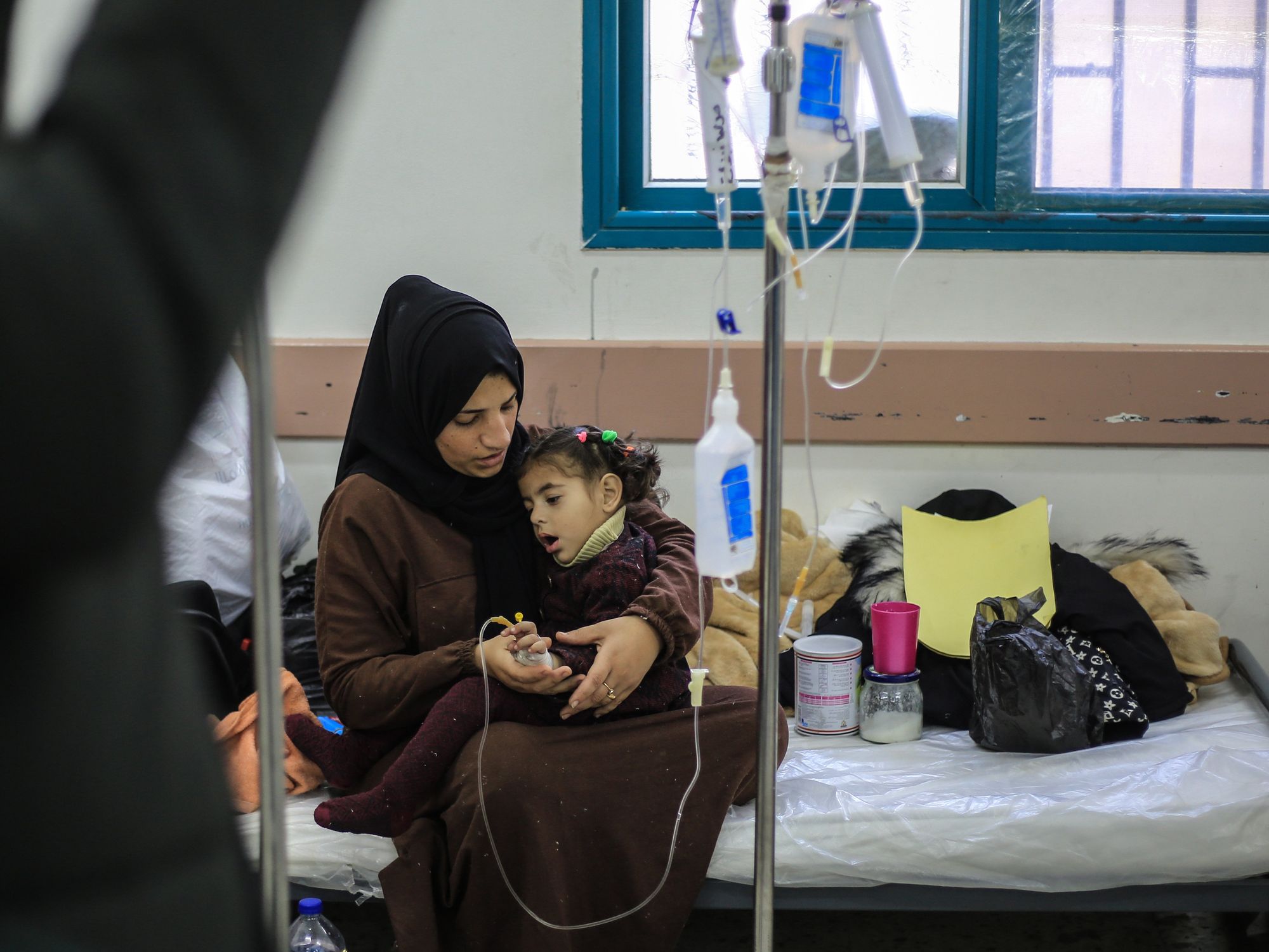 photo of a woman holding a young girl who has an IV