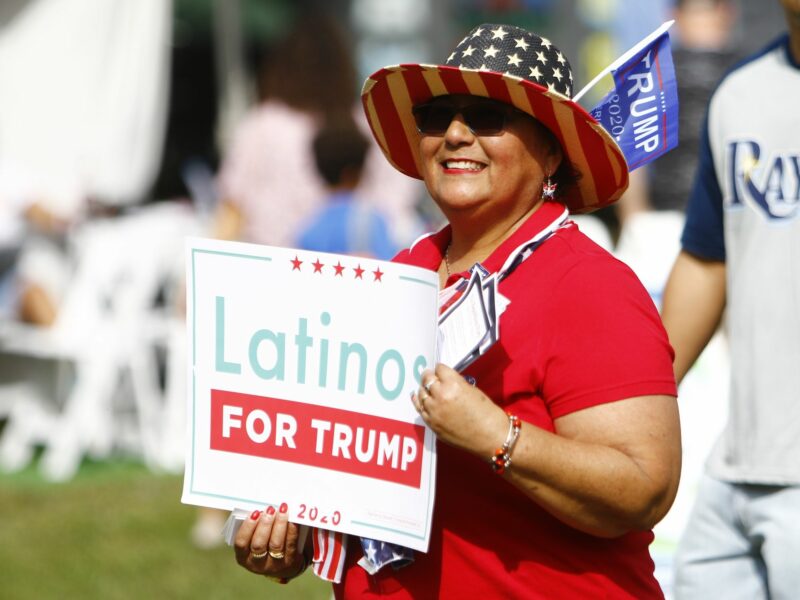 photo of a woman holding Latinos for Trump sign