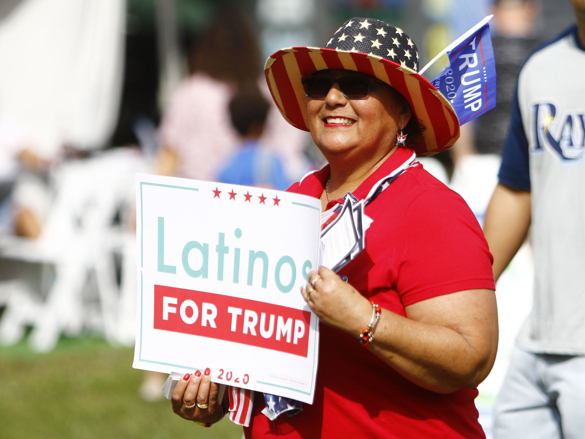 photo of a woman holding Latinos for Trump sign