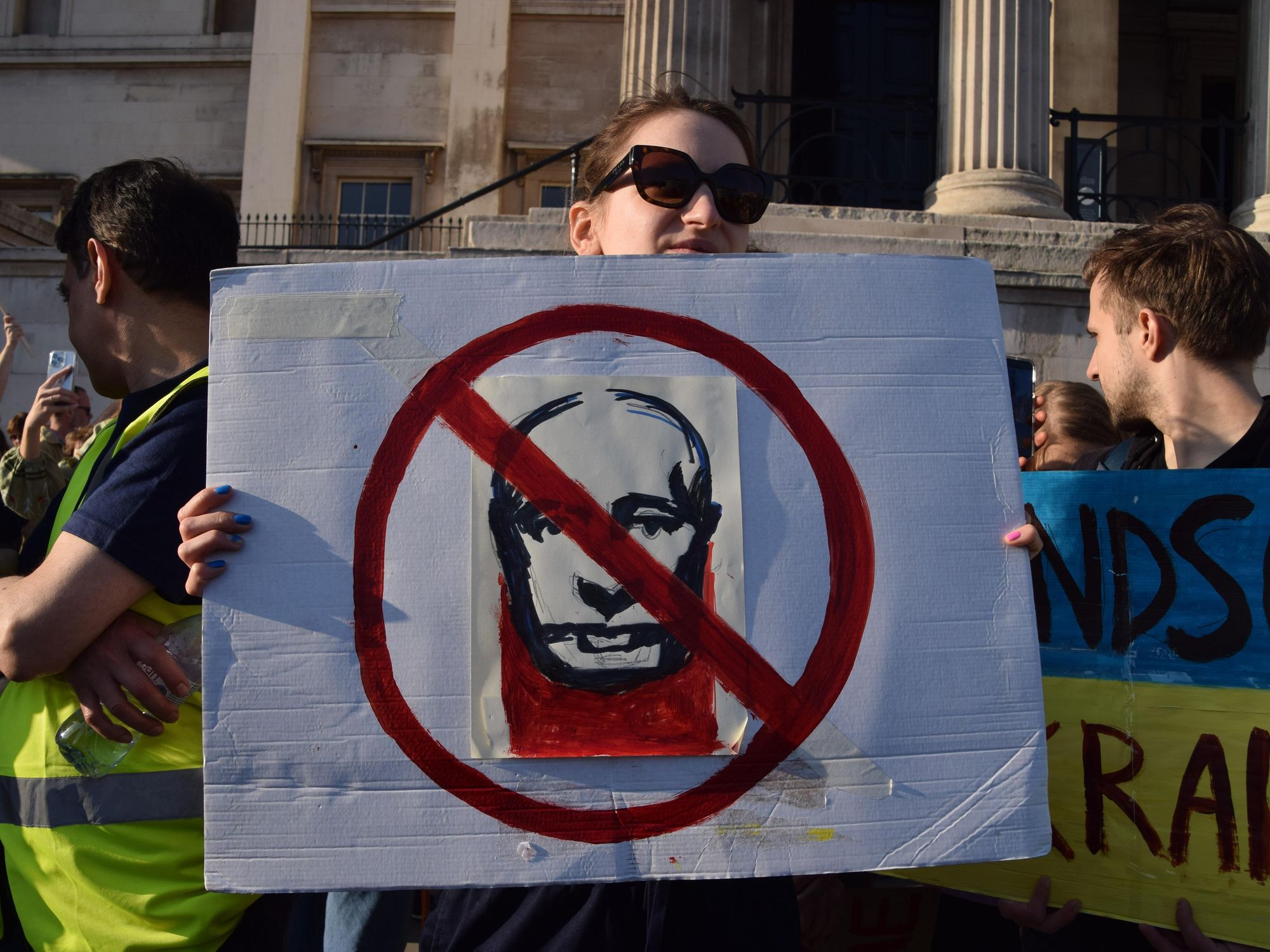 photo of a woman holding up an anti putin sign