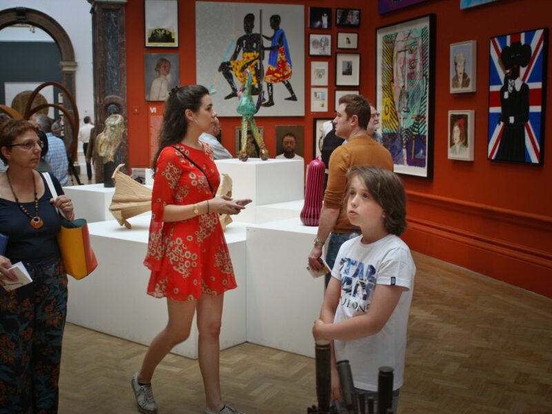 photo of a woman in a red dress and other people at a musuem