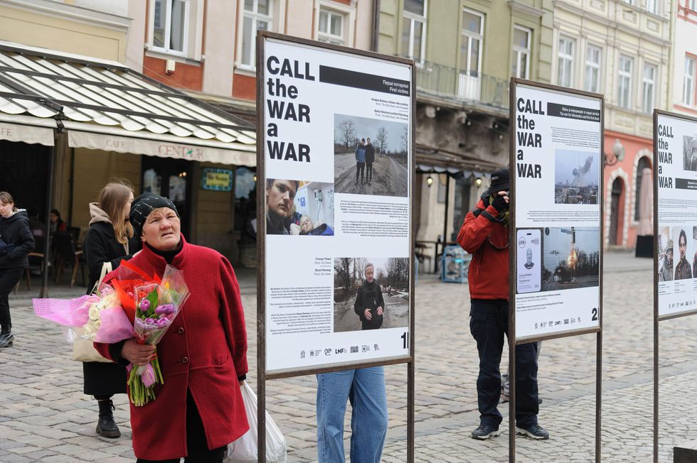 Photo of a woman looking at the exhibition "Call the War a War" in Lviv, Ukraine