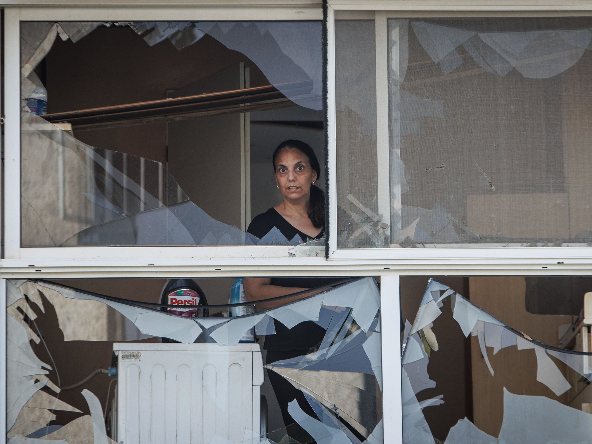 photo of a woman looking through broken glass.