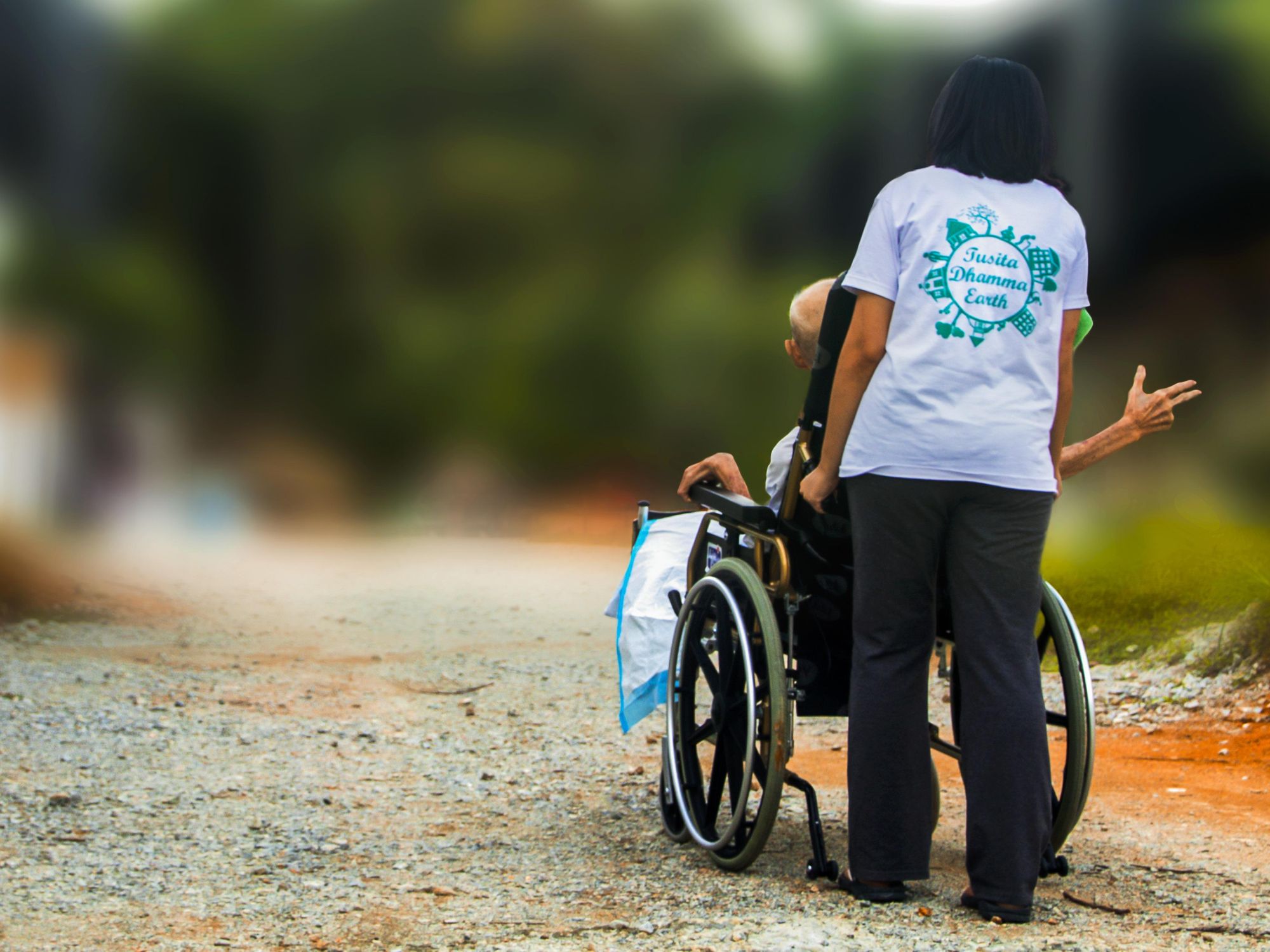 photo of a woman pushing an elderly man in a wheelchair
