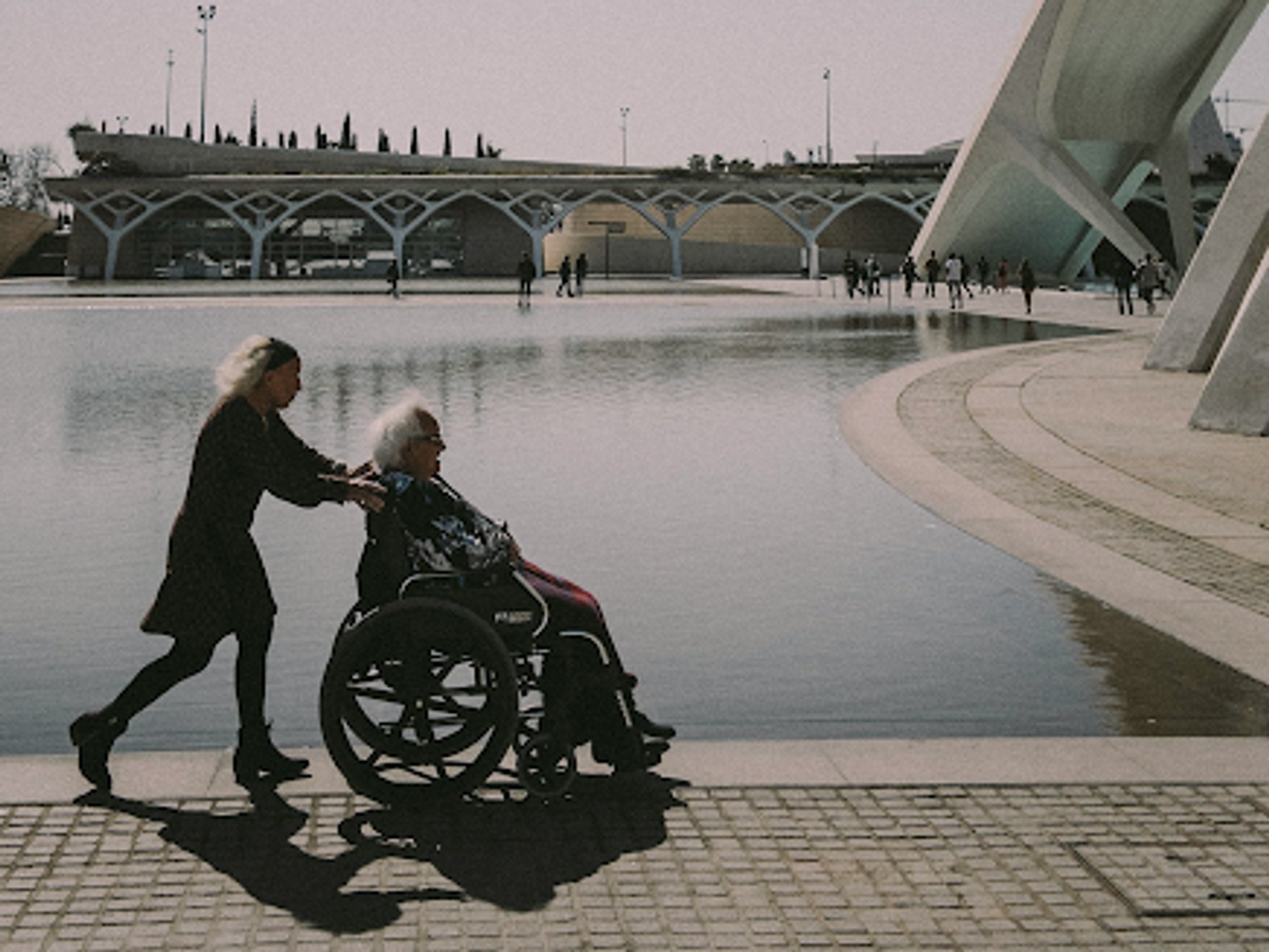 photo of a woman pushing someone in a wheelchair