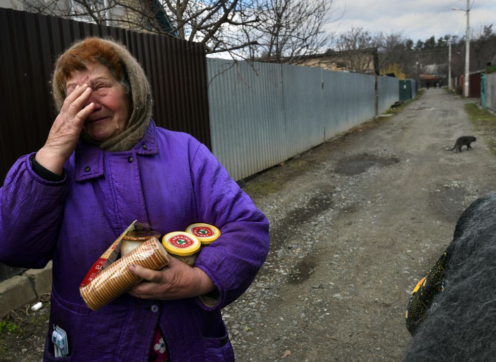 Photo of a woman receiving supplies in the streets of Bucha