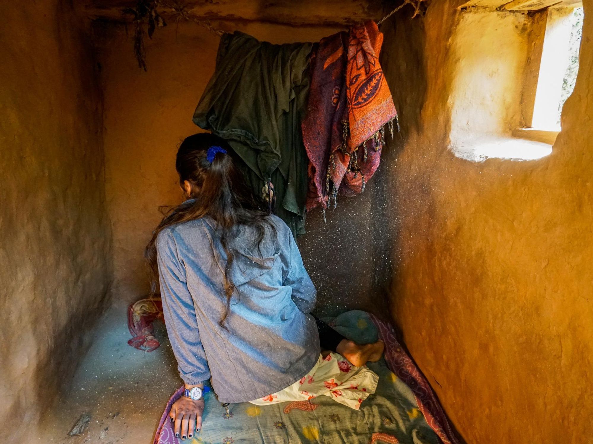 Photo of a woman sitting inside a menstrual hut in Nepal