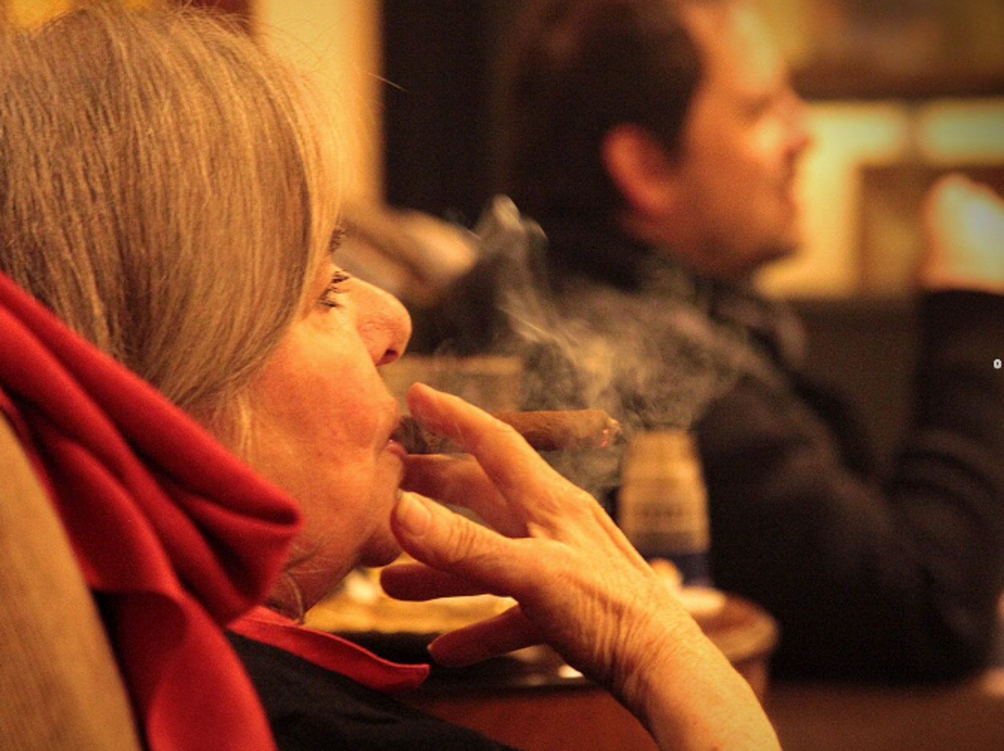 Photo of a woman smoking a cigar.