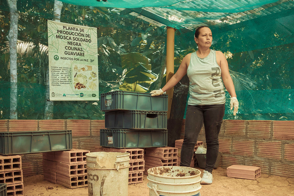 Photo of a woman standing with the cultivated insects.