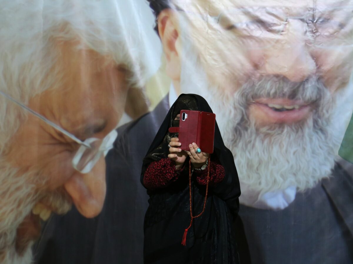 photo of a woman taking a selfie in front of supreme leader