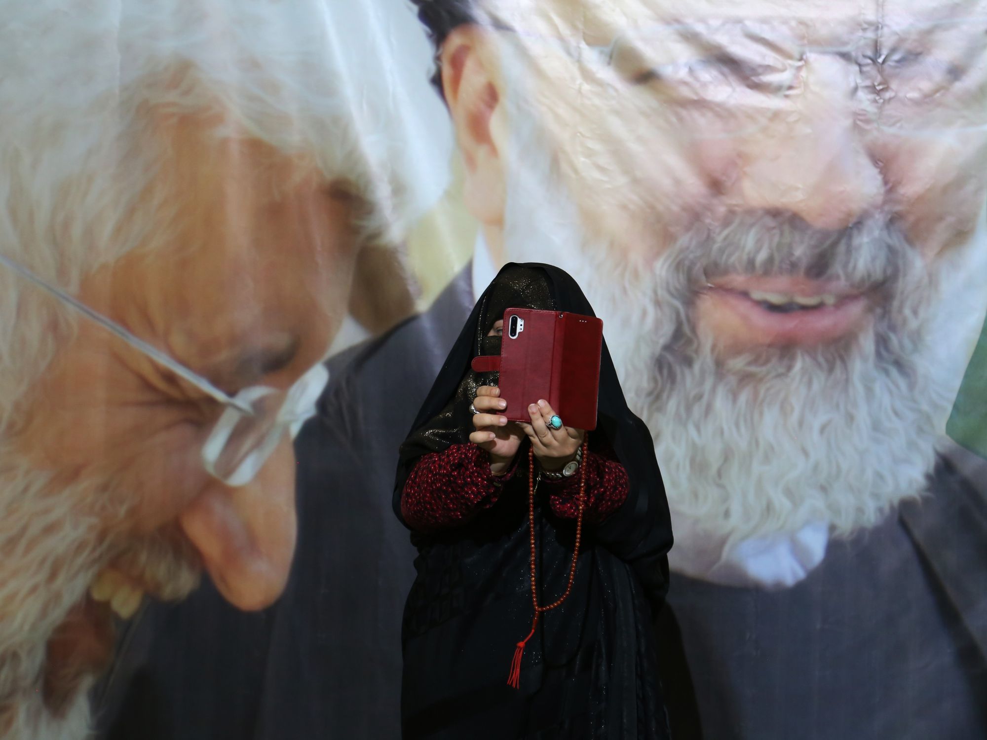 photo of a woman taking a selfie in front of supreme leader