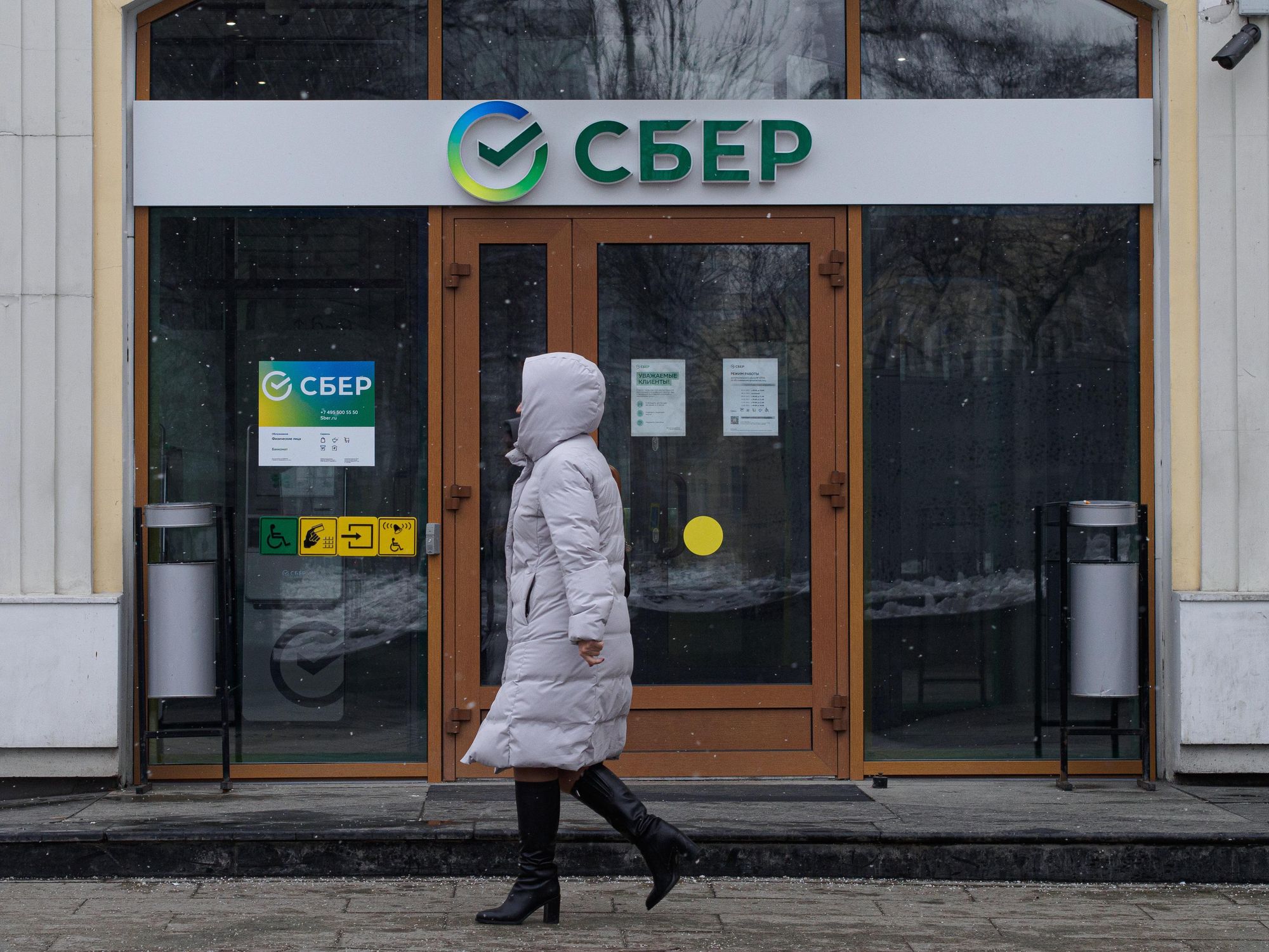 Photo of a woman walking past the office of Sberbank in Moscow