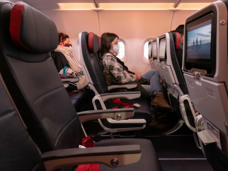 Photo of a woman wearing a face mask on a plane