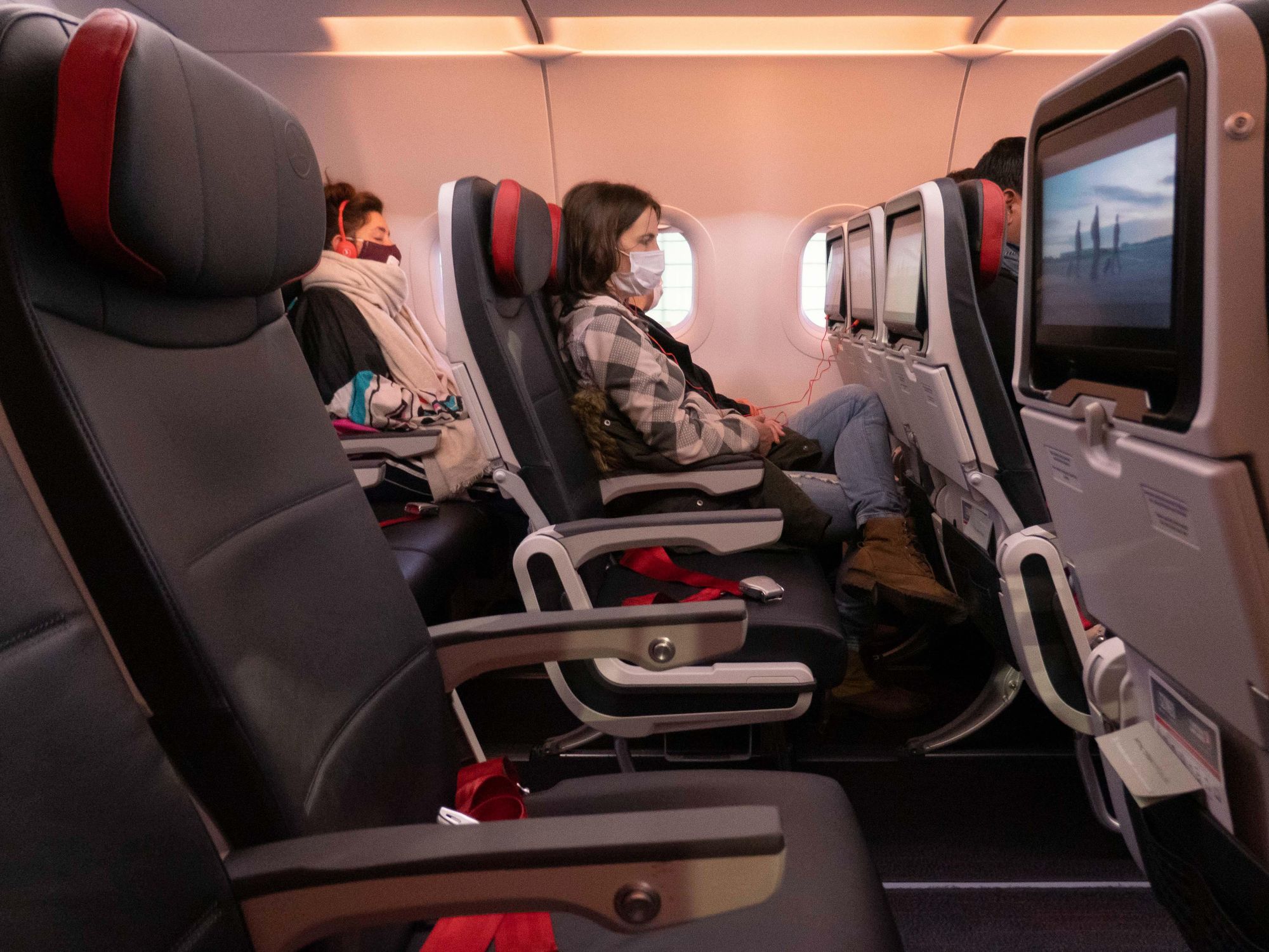 Photo of a woman wearing a face mask on a plane