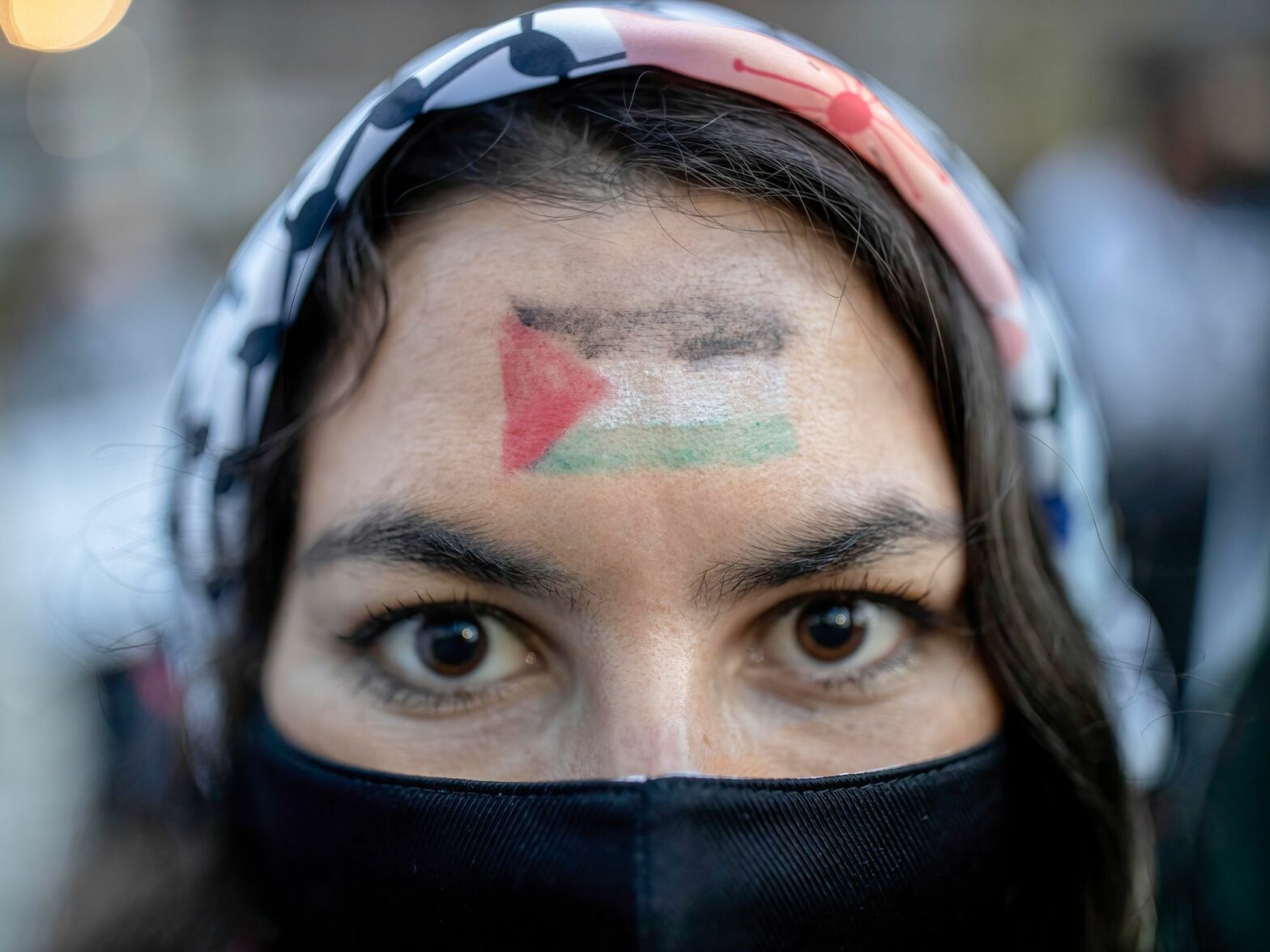 Photo of a woman with a Palestinian flag painted on her face during a rally
