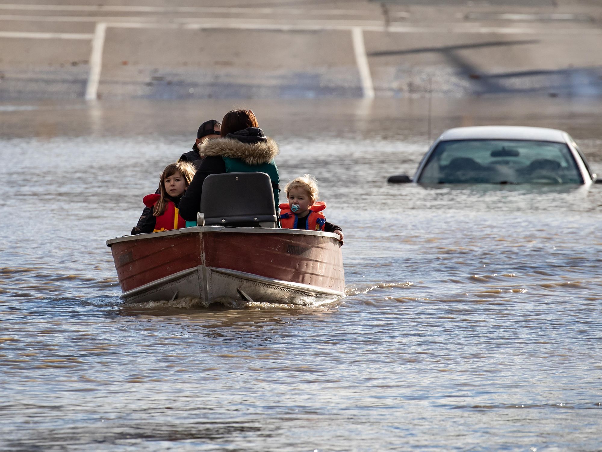 Photo of a woman with her children stranded in high water in Abbotsford, British Columbia following massive floods triggered by torrential rains in western Canada.